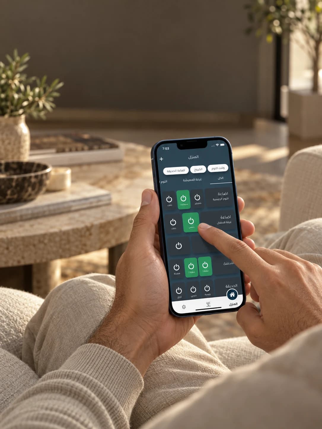 A person relaxing on a sofa and using the Autobayt app’s Arabic home controls